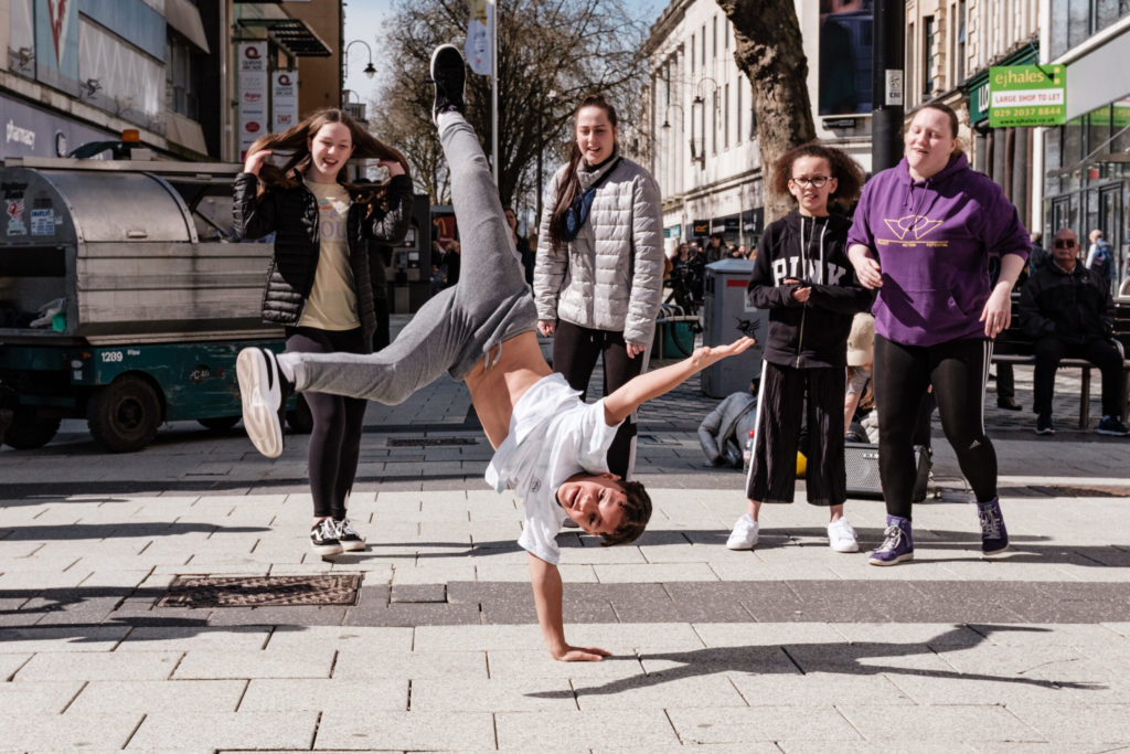 Group of 5 children and young teenagers dancing in street