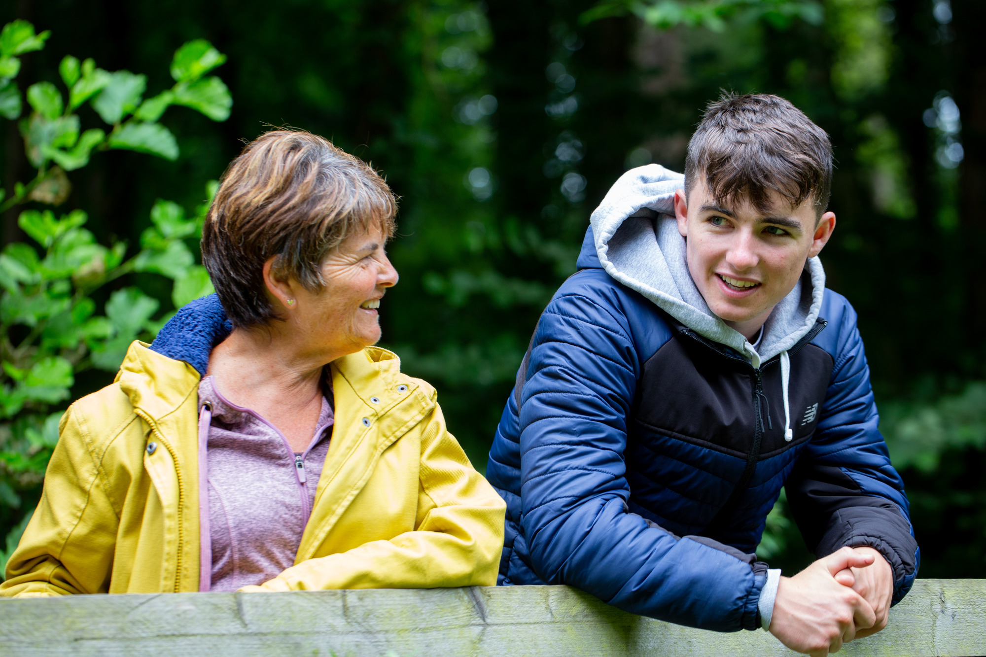 A woman and a young man talking and laughing outdoors