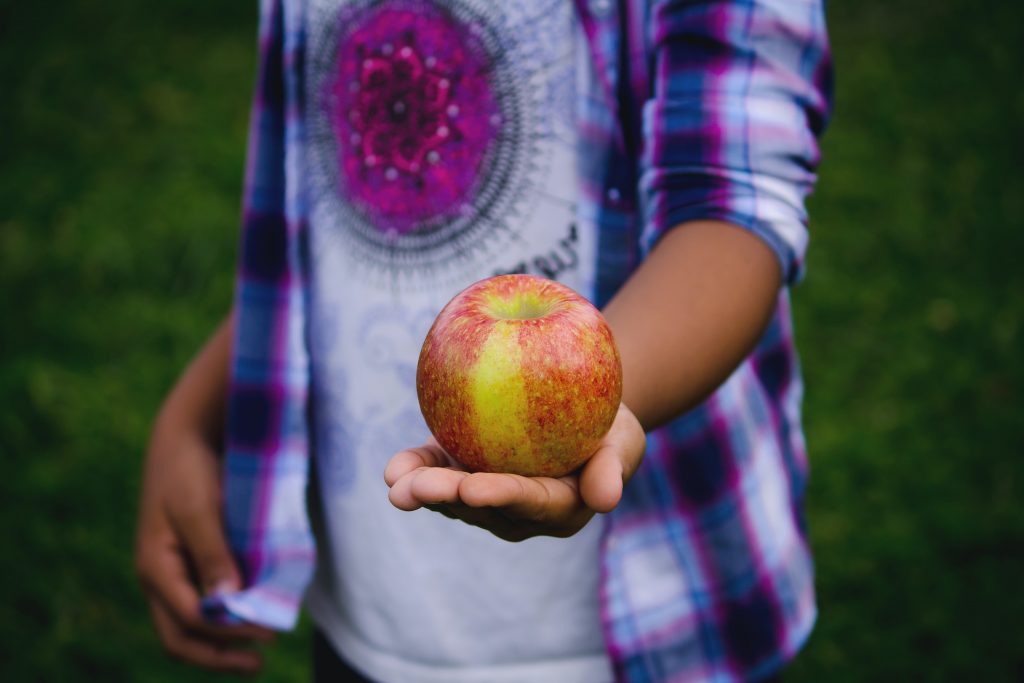 A person holding an apple. Bonnie Kittle on Unsplash
