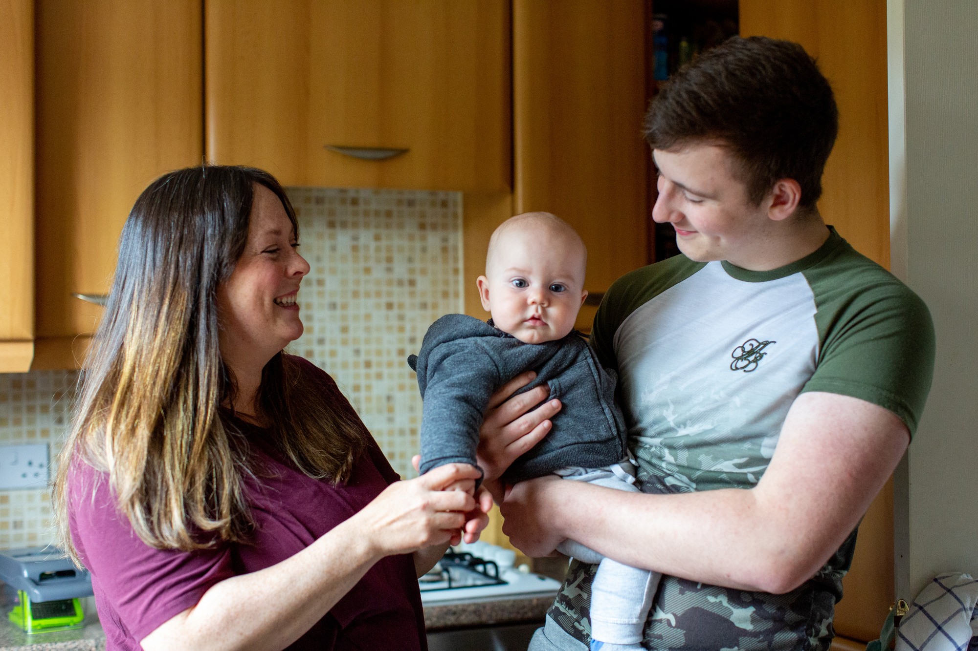 A woman and a man holding a baby